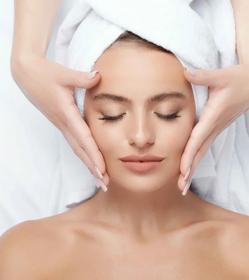 Person receiving a facial treatment with a spa applicator on forehead.