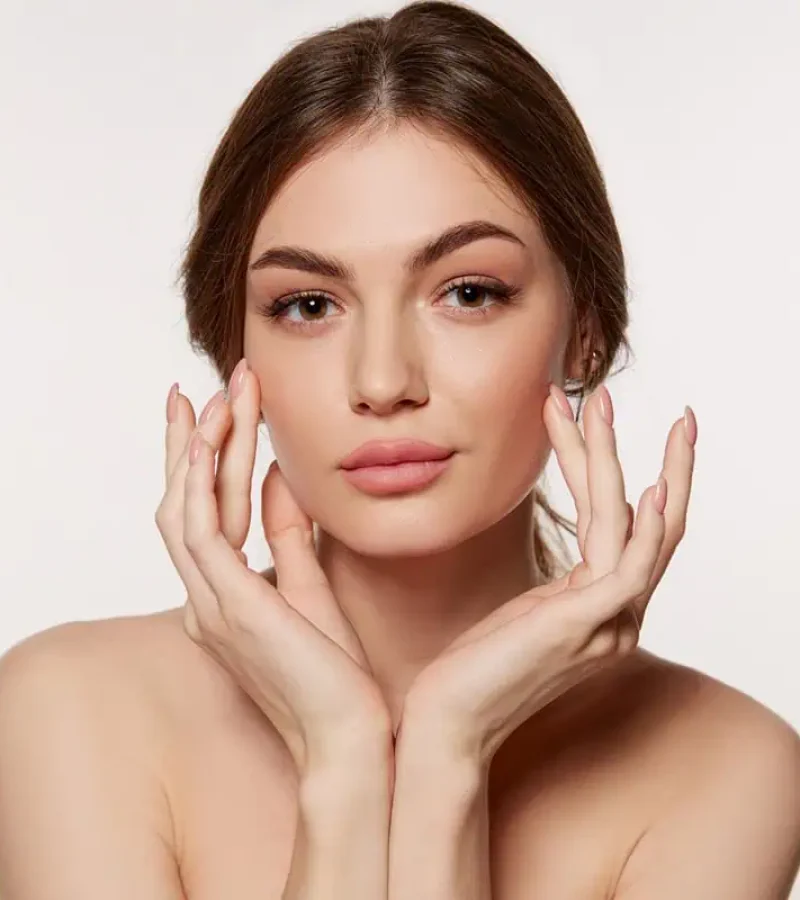 oung woman touching her smooth glowing skin after facial treatment at Gemini Glow Medspa in Taylorsville, UT.”