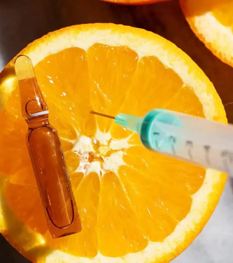 Vitamin injection with orange and syringe symbolizing wellness treatment at Gemini Glow Medspa in Taylorsville, UT