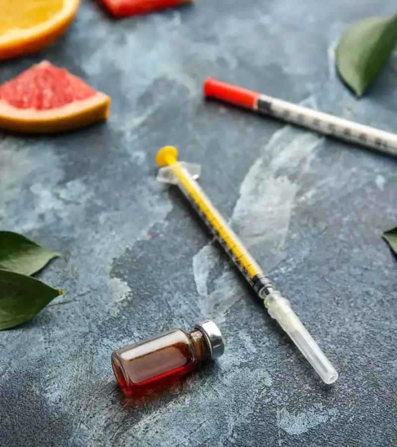 Vitamins and syringe displayed vitamin on table representing injection therapy at Gemini Glow Medspa in Taylorsville, UT.