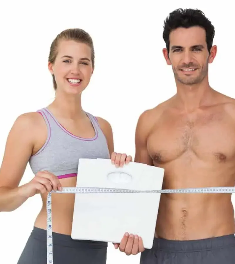 Smiling couple holding blank board promoting wellness services at Gemini Glow Medspa in Taylorsville, UT
